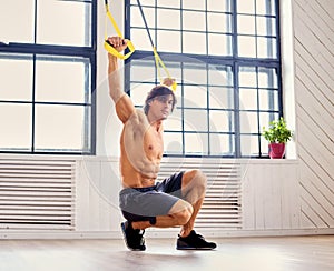 A man doing workouts with suspension trx straps.