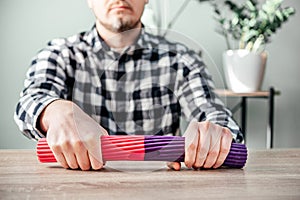 A man doing wrist exercises with theraband flexbar
