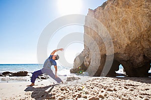 Man doing Yoga on a beach near the ocean
