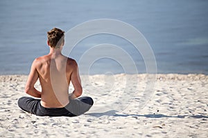 Man doing yoga on the beach