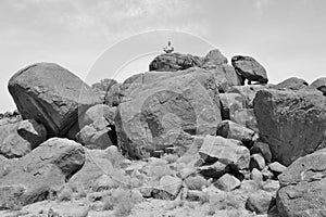 Man doing yoga concentration on a pile of rocks #3 -B&W-