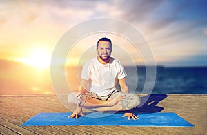 Man doing yoga scale pose outdoors