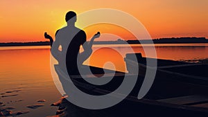 Man doing yoga at sunset