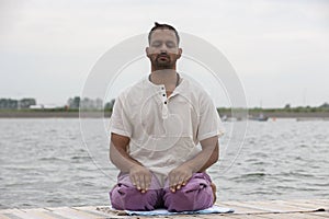 Man doing yoga on a wooden floor in the nature