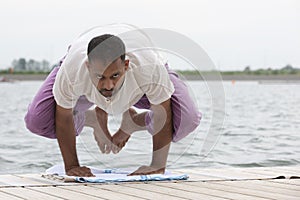 Man doing yoga on a wooden floor in the nature