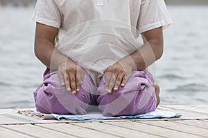 Man doing yoga on a wooden floor in the nature