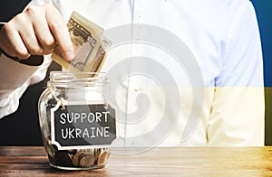 A man donates money to support Ukraine. Financial assistance to Ukrainian refugees who suffered from the aggression of the Russian