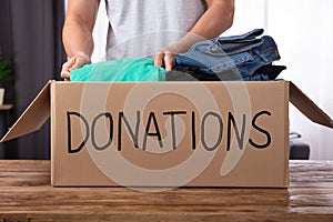 Man Donating Clothes In Donation Box