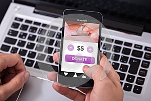 Man Donating Money On Mobile Phone