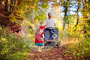 Man with double pushchair. Father and kids walk