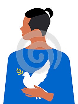 A handsome young guy with a modern teenage haircut holds a white dove of peace in his hands on a vertical background.