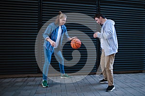 Man with down syndrome playing basketball outdoor with his friend. Concept of friendship and integration people with