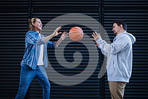 Man with down syndrome playing basketball outdoor with his friend. Concept of friendship and integration people with