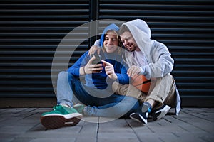 Man with down syndrome resting during basketball playing outdoor with his friend. Concept of friendship and integration
