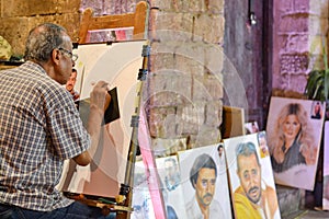 A man draw then paint from customer`s photo at Muizz Li Dinillah street