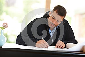 Man, drawing and architect with plan for design in office, documents and writing on blueprint. Male person, drafting and