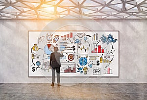 Man drawing startup sketch in geometric ceiling room, toned