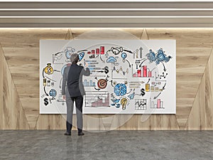 Man drawing startup sketch in wooden walls room