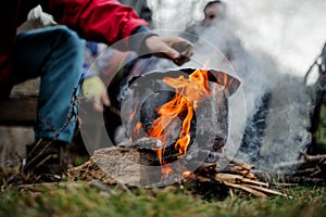 Man drawn by hand to the black pan standing on the bonfire