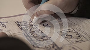 The man draws in a notebook,taking notes, the person writes in a diary, notebook. Writing