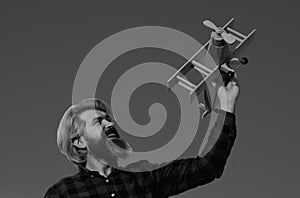 Man dream. Bearded man dreams with plane. Daydreamer. Dreams and imagination. Dreamy father. Man play with toy plane photo