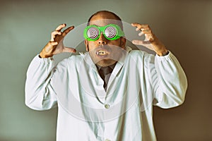 Man dressed as a mad scientist with a lab coat, crazy glasses, and vampire teeth