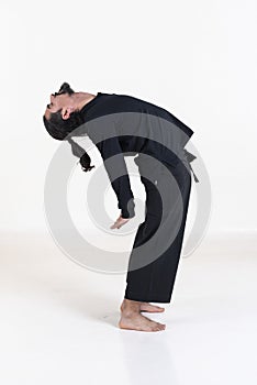 A man dressed in black doing yoga over white background. .Suryanamaskar yoga pose