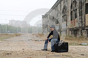Man dressed in black with hat sitting smoking photo