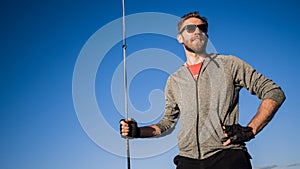 Man dressed in casual wear and sunglasses on a yacht. Happy adult bearded yachtsman close-up portrait. Handsome sailor