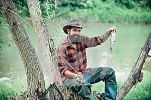 Man dressed in shirt fishing with rod and fish on the lake. Weekend. Master baiter. Male hobby. Hobby and recreation