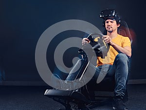 Man wearing VR headset driving on car racing simulator cockpit with seat and wheel.