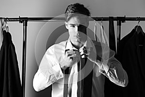 Man dressing. Sexy gay with formal outfit tie and suit wearing shirt and tie. Young businessman in white shirt putting