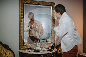 Man dressing up in front of mirror preparing for night out