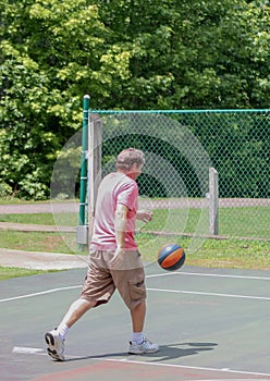 Man dribbles basket ball photo