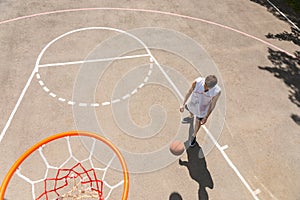 Man Dribbling Basketball in Key of Court