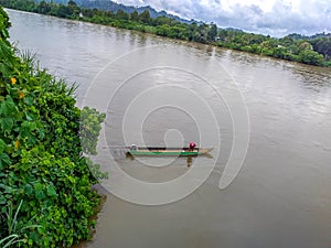 a man drifting his boat on Mentarang River, Malinau, Borneo