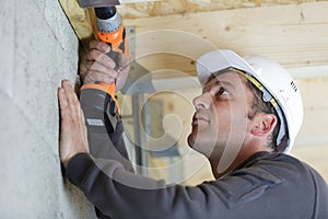 man drilling ceiling