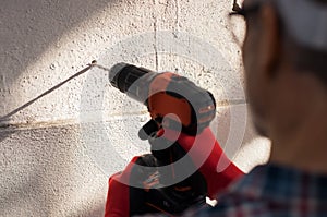 Man drilling hole in wall