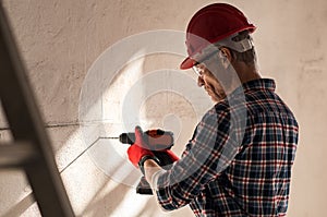 Man drilling hole in wall