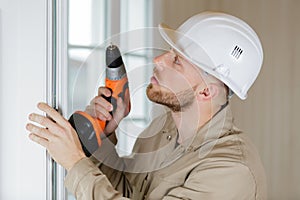 man drilling wall with drill perforator