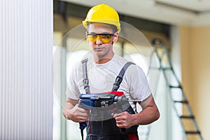 The man drilling the wall with drill perforator