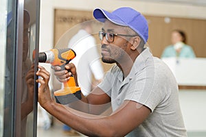 man drilling wall in hospital