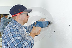 Man drilling wall with impact drill