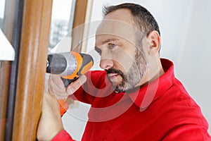 Man drilling window
