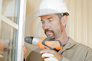 man drilling window