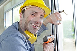 man drilling window frame