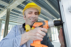 man drilling window frame