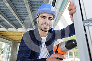 man drilling window frame