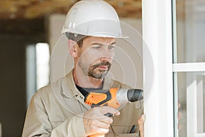 Man drilling window frame