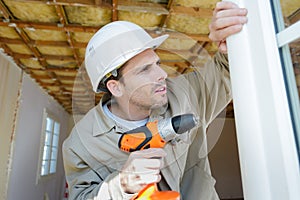 Man drilling window frame